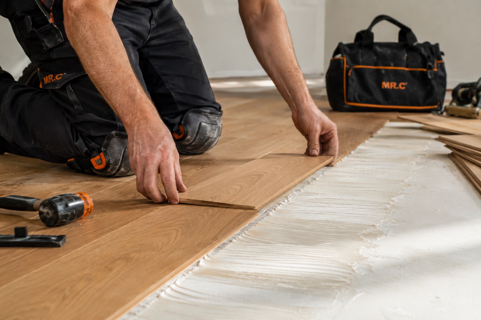 Flooring renovation in Aurora — Mr.Contractor installer laying engineered hardwood flooring in a Toronto home
